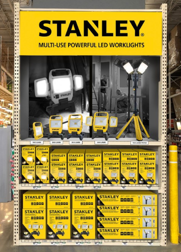 Stanley worklight display at a store; yellow and black packaging; includes multiple worklights and tripod.