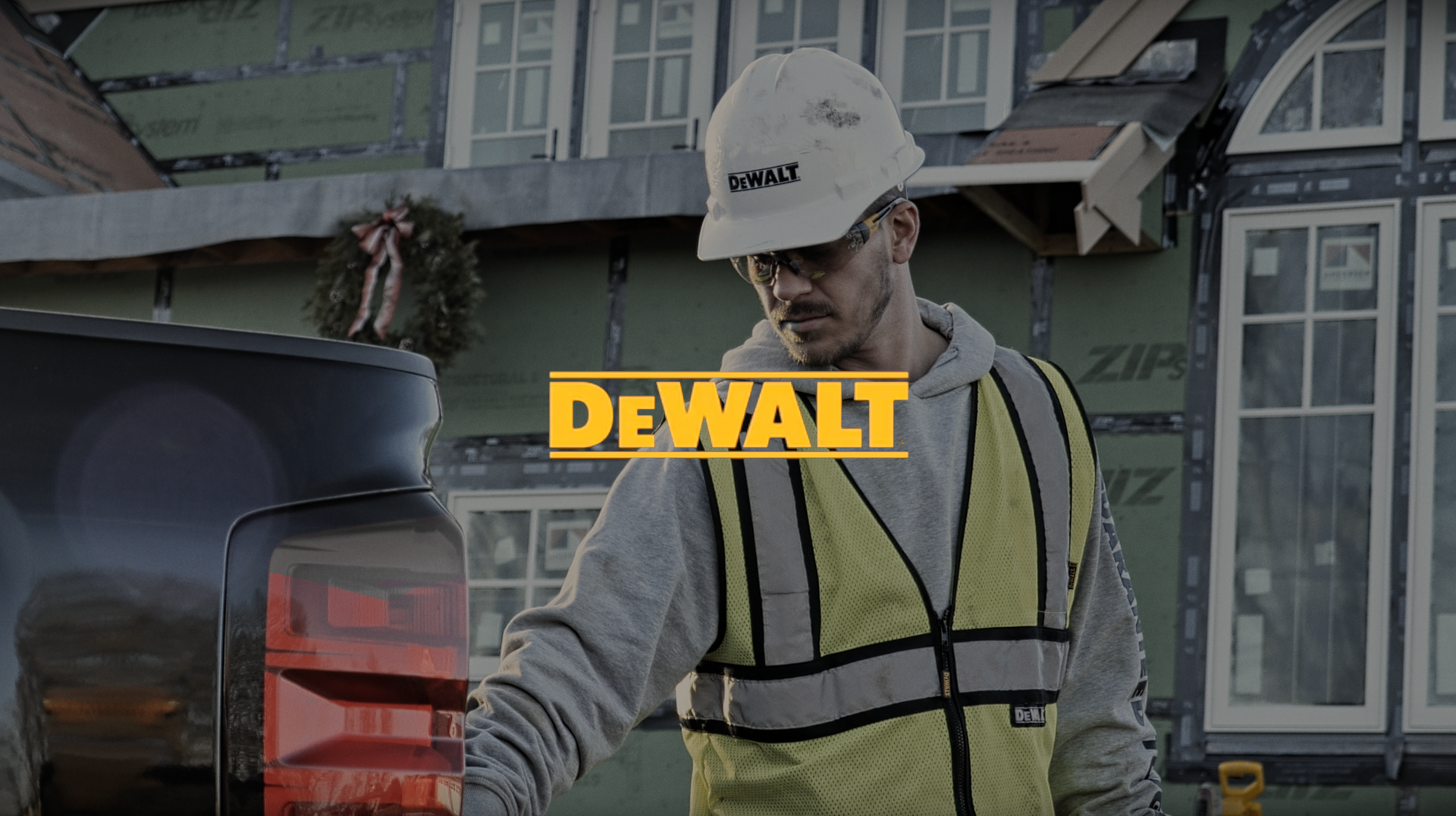 Man in hard hat and vest, working construction outside, DeWalt logo overlay.