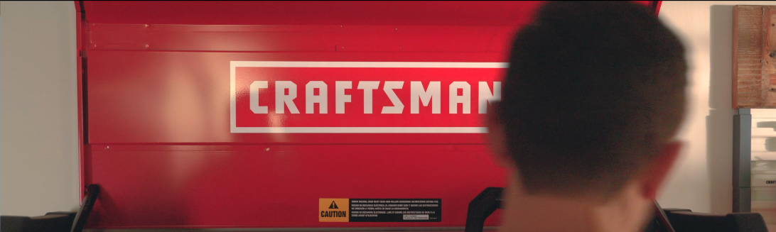 A person looking at a Craftsman toolbox, the red toolbox has a white logo.