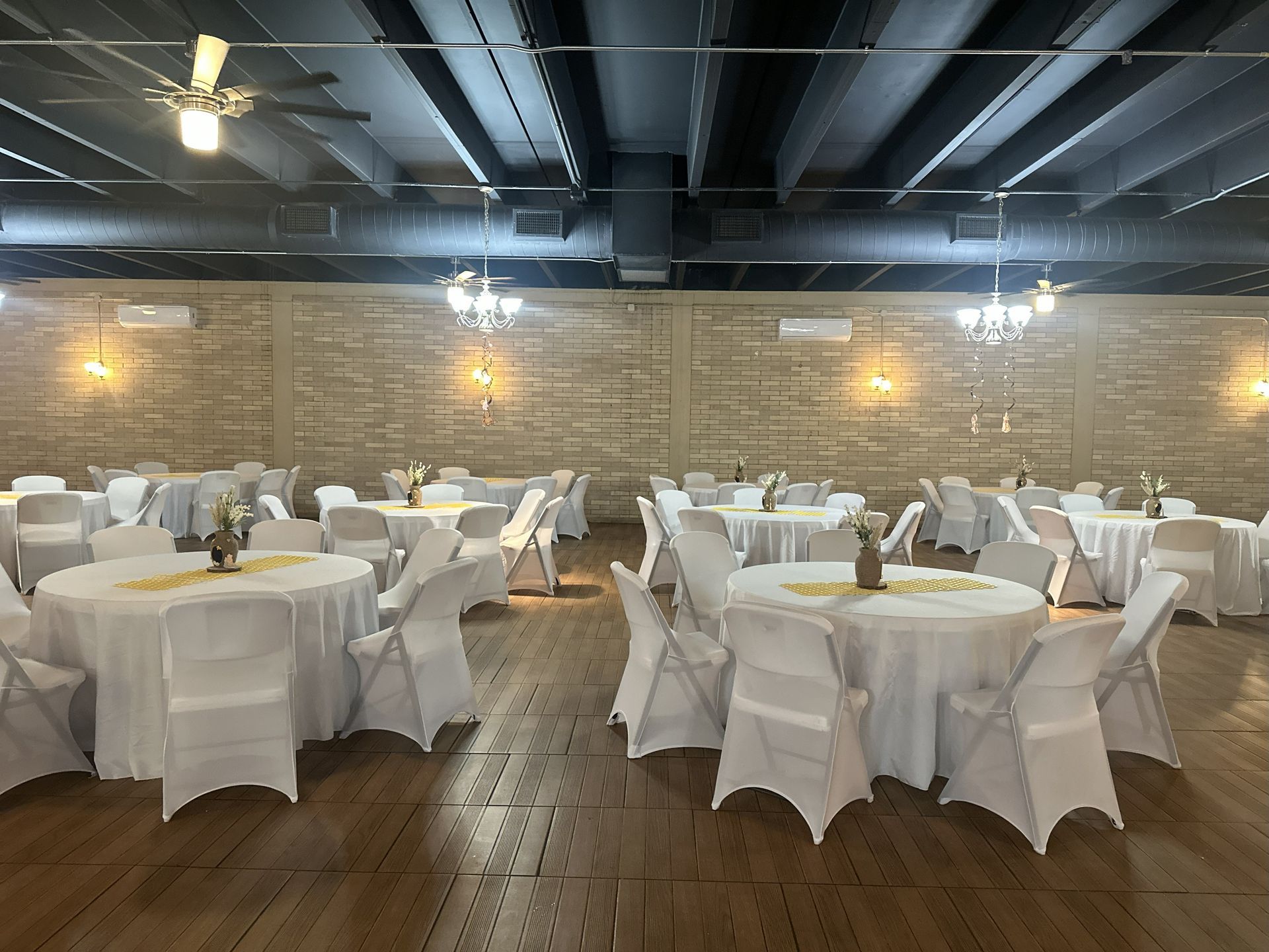 Event space with round tables covered in white linens, set for a gathering.
