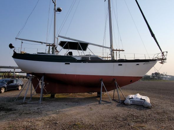 A group of boats are docked in a marina in front of a building.