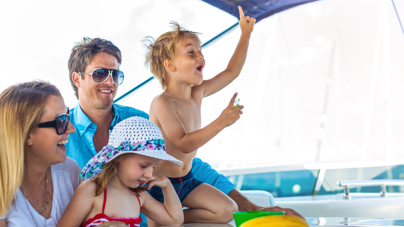 A family is sitting on a boat playing with a kite.