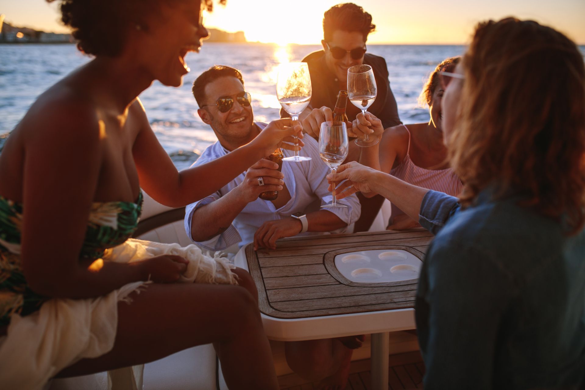 A group of people are toasting with wine glasses on a boat.
