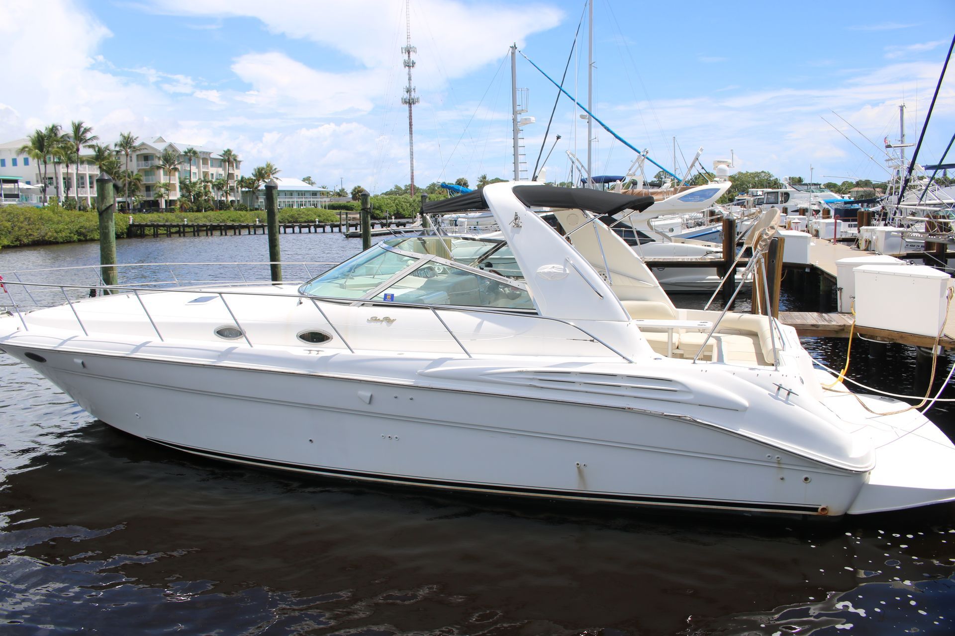 A white boat is docked at a marina on a sunny day