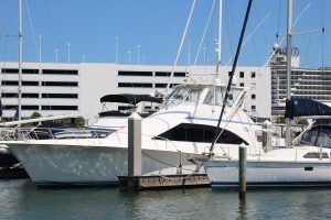 A group of boats are docked in a marina in front of a building.