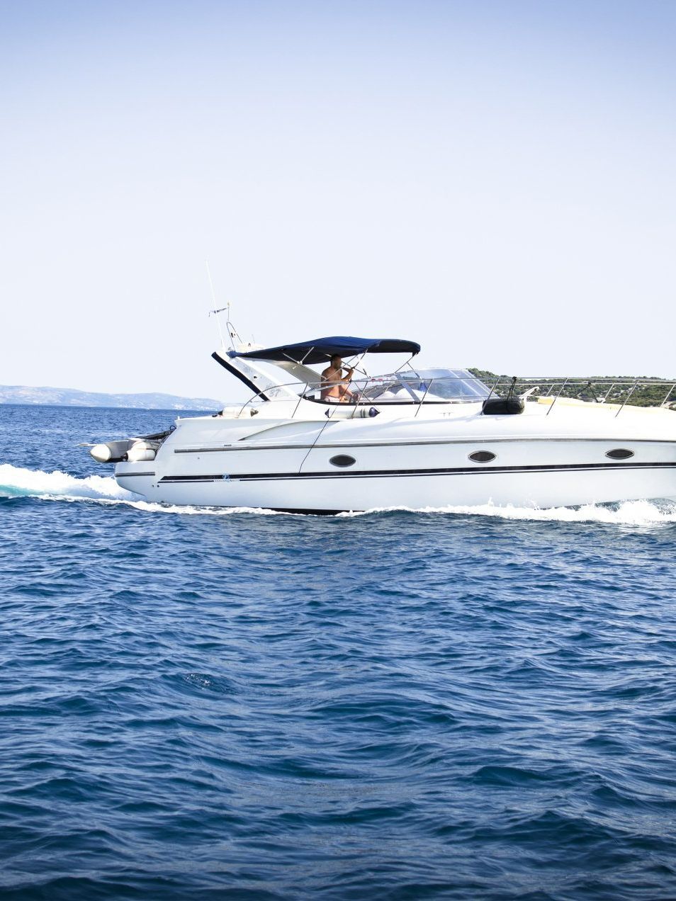 A white yacht is floating on top of a large body of water.
