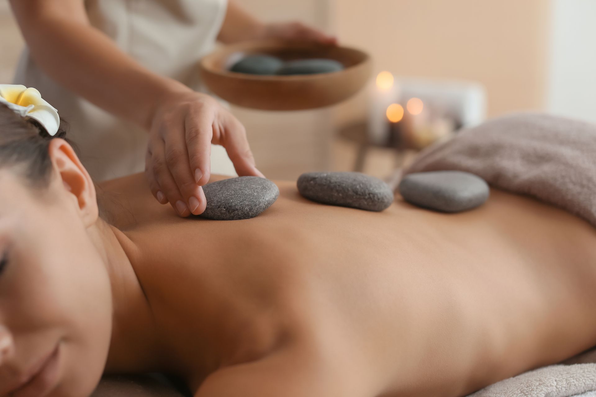 A woman is getting a hot stone massage at a spa.