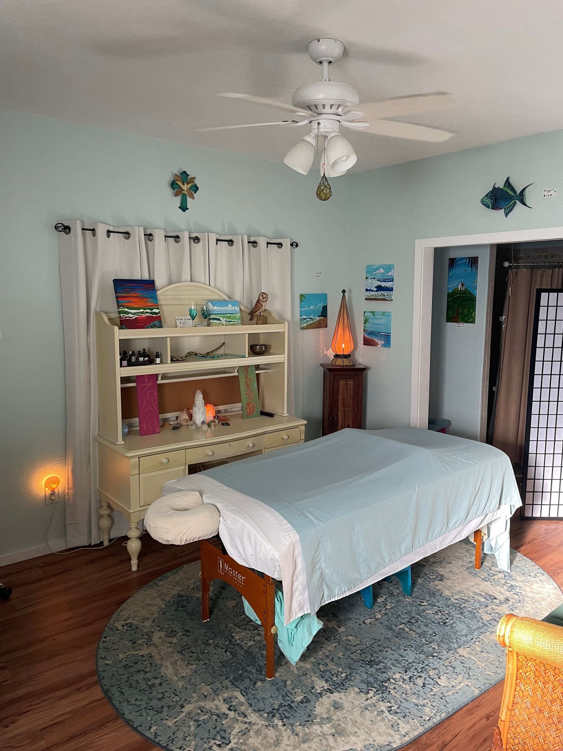 A massage table in a room with a ceiling fan.