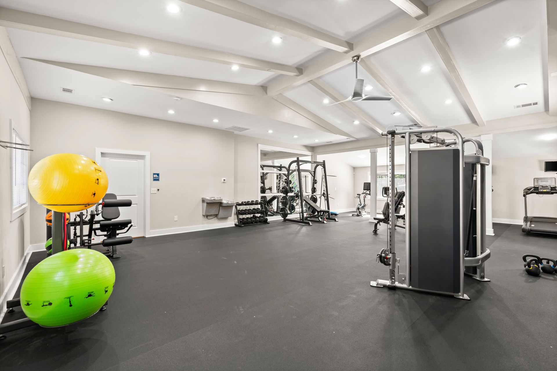 Gym interior with exercise equipment and fitness balls on black rubber flooring at The Arbors at Smyrna, offers apartments in Cobb County.