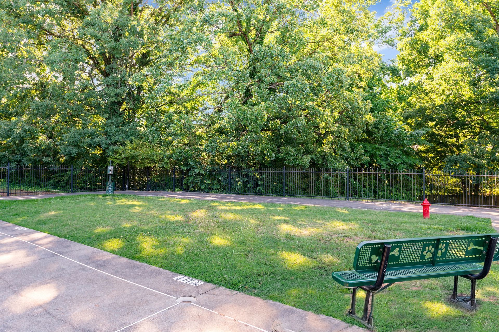 Green park with bench, grass, trees, and a red fire hydrant at The Arbors at Smyrna, offers townhomes in Smyrna, GA.