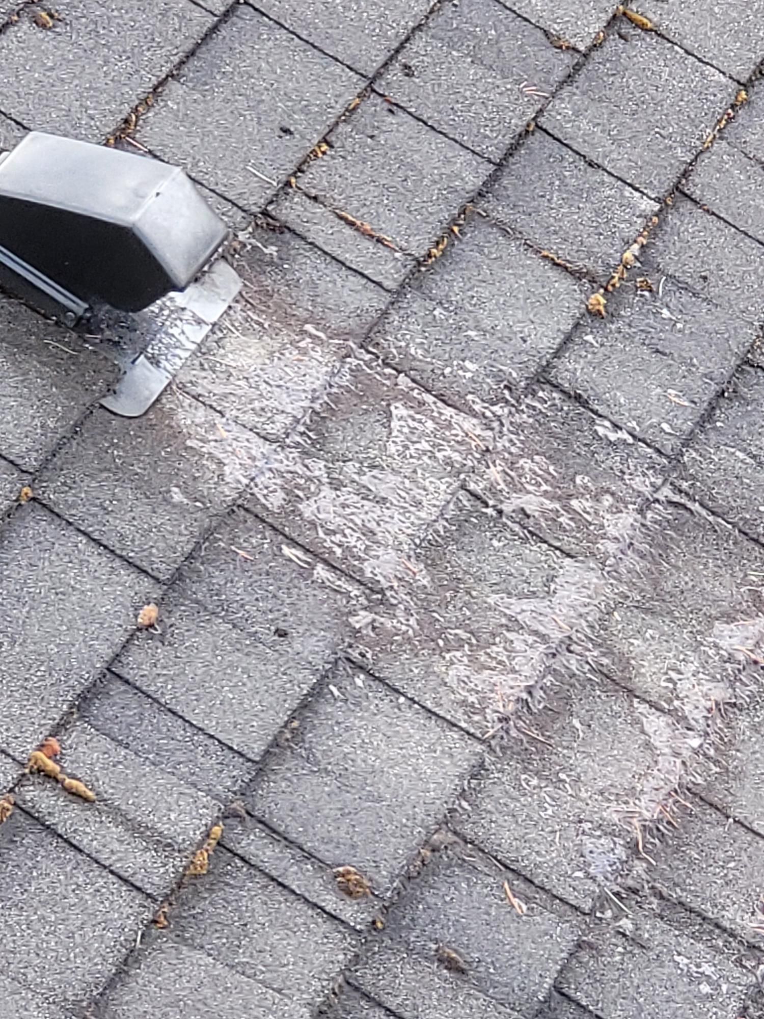 A close up of a brick roof with a drain on it.
