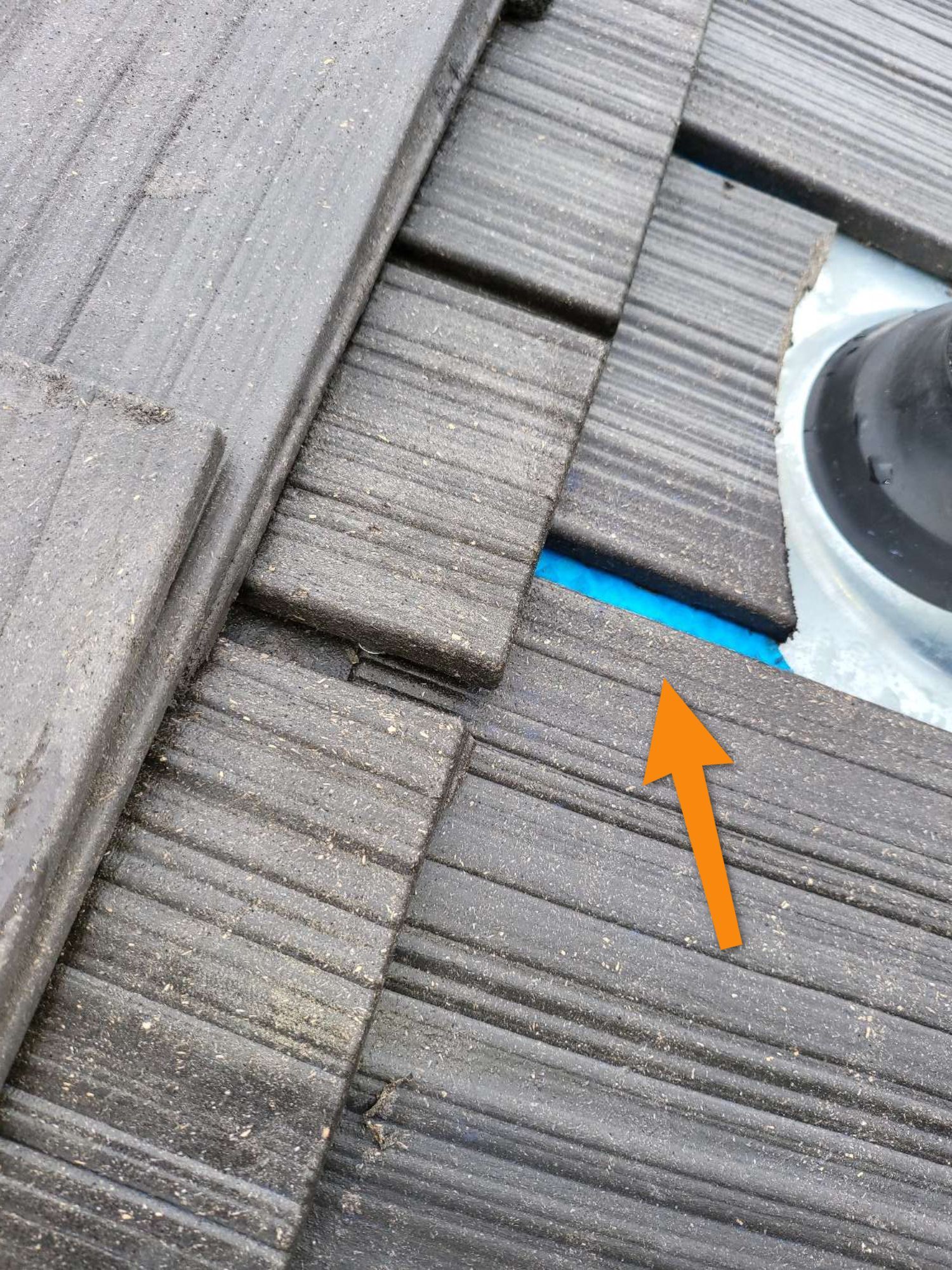 A close up of a wooden deck with an orange arrow pointing to it.