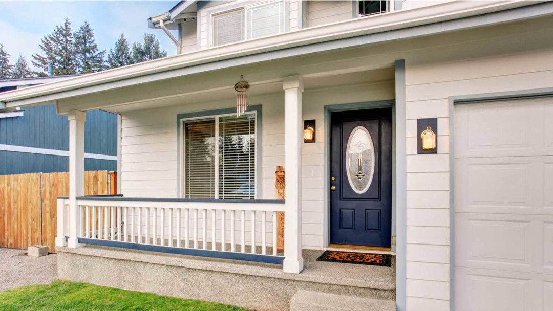 A white house with a blue door and a porch.