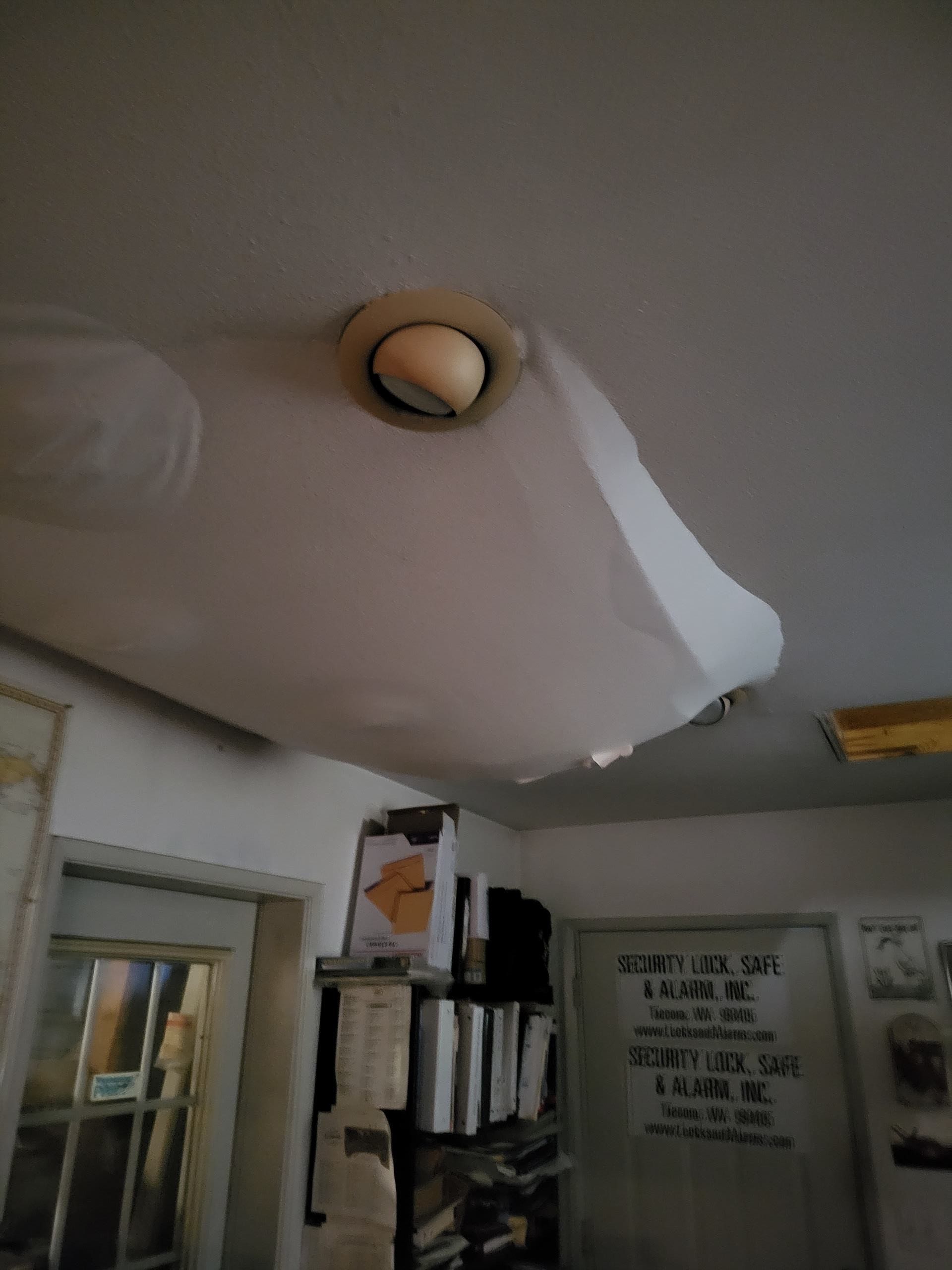 A white cloth is hanging from the ceiling in a room