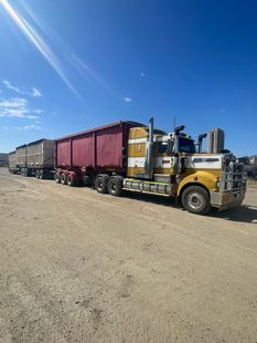 Blue dumpster on a truck, indoors.