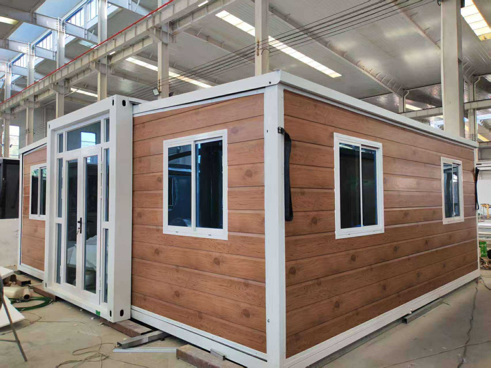 Modular house unit with wood-look siding, white trim, and multiple windows. — Expandable Housing in Inala, QLD