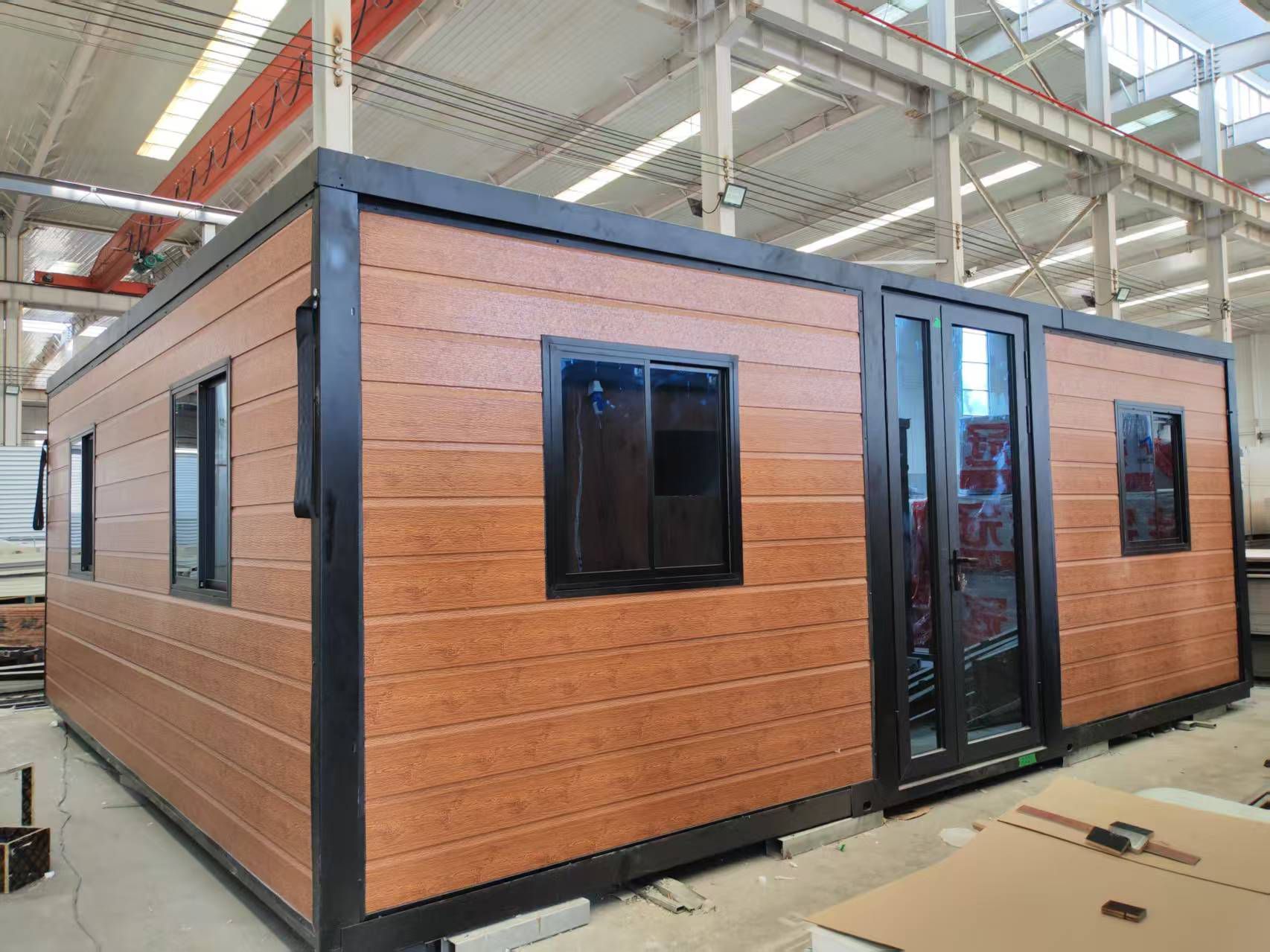 Brown modular building with black trim, windows, and double doors; indoors. — Expandable Housing in Inala, QLD