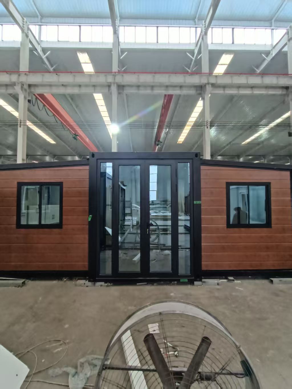 Modular Building With Brown Siding and Glass Doors in a Warehouse — Expandable Housing in Inala, QLD