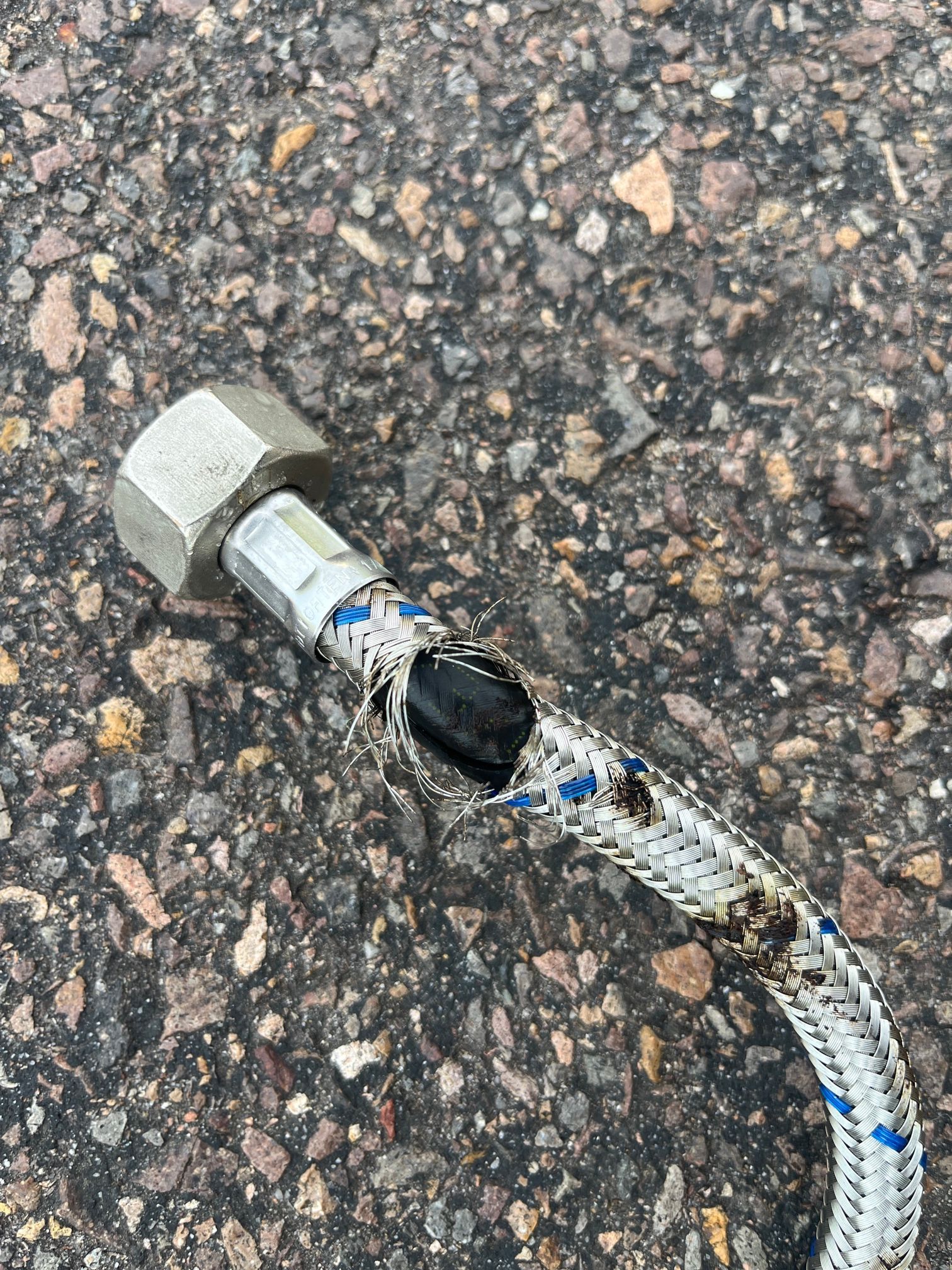 Hand Pointing to a Corroded, Broken Pipe Buried in Dirt — Huddo's Plumbing Service in Wallalong, NSW