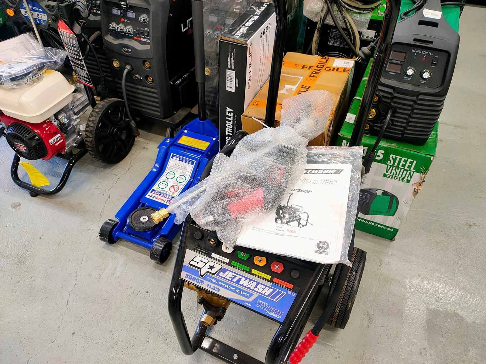 A Pressure Washer Is Sitting On Top Of A Blue Floor Jack — PT Trade Supplies in Port Macquarie, NSW
