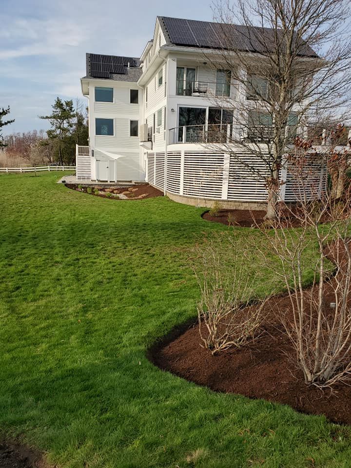 A large white house with a large lawn in front of it.
