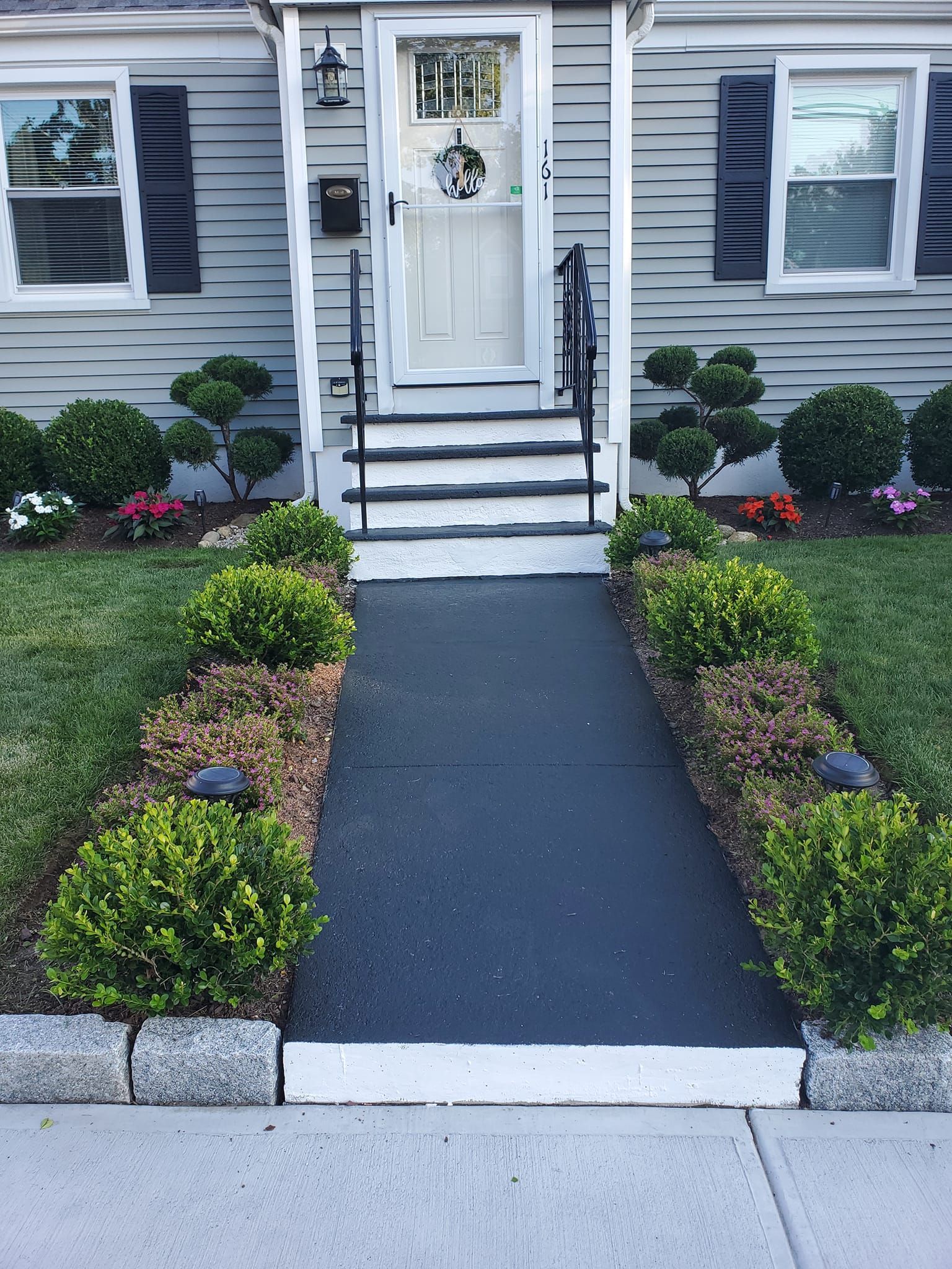 A house with a walkway leading to the front door and stairs.