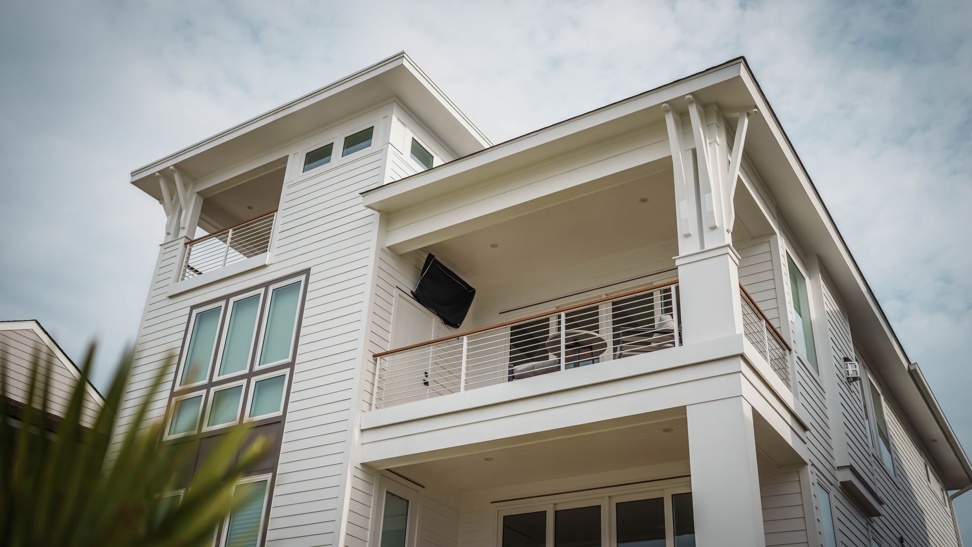 A large white house with a balcony on the second floor