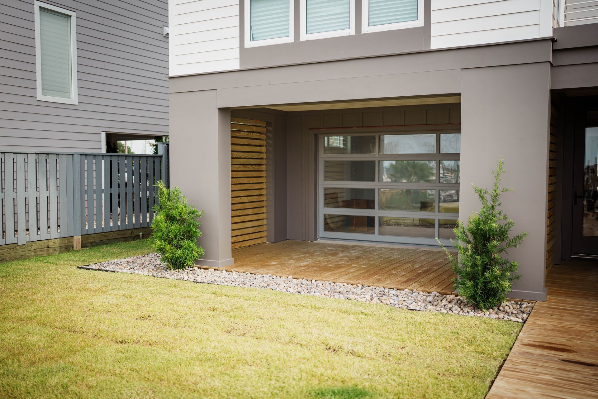 A house with a lawn in front of it and a garage door