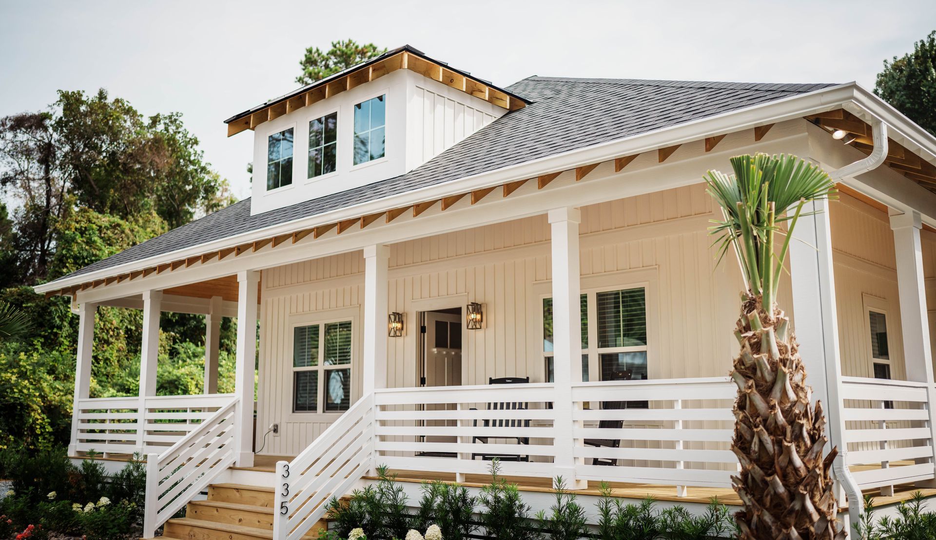 A large white house with a porch and stairs