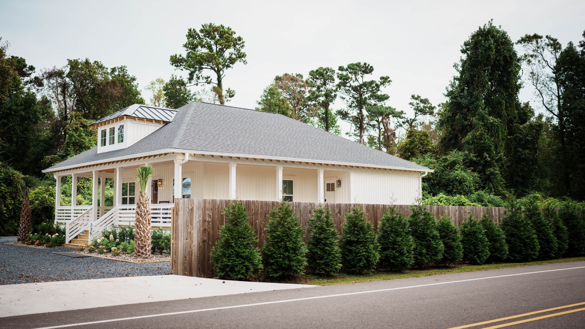A white house with a wooden fence surrounding it