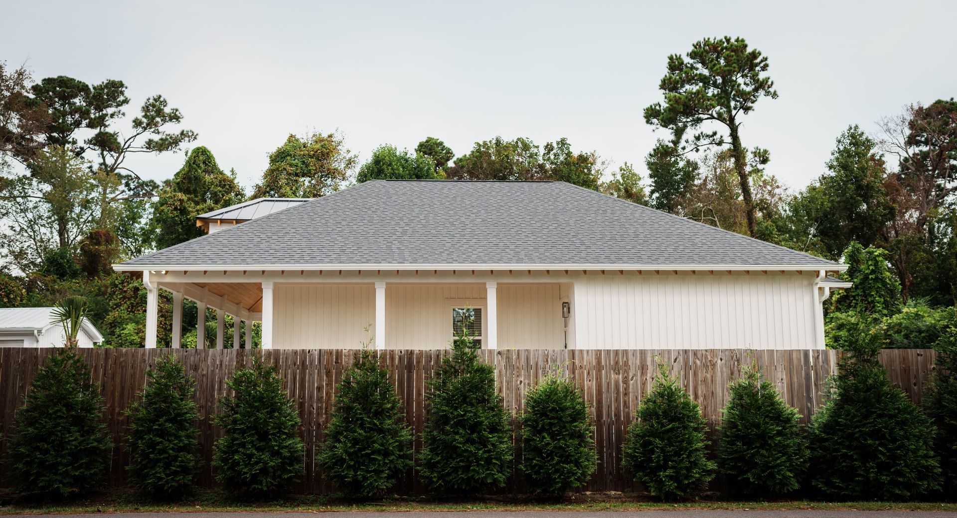 A white house with a wooden fence in front of it