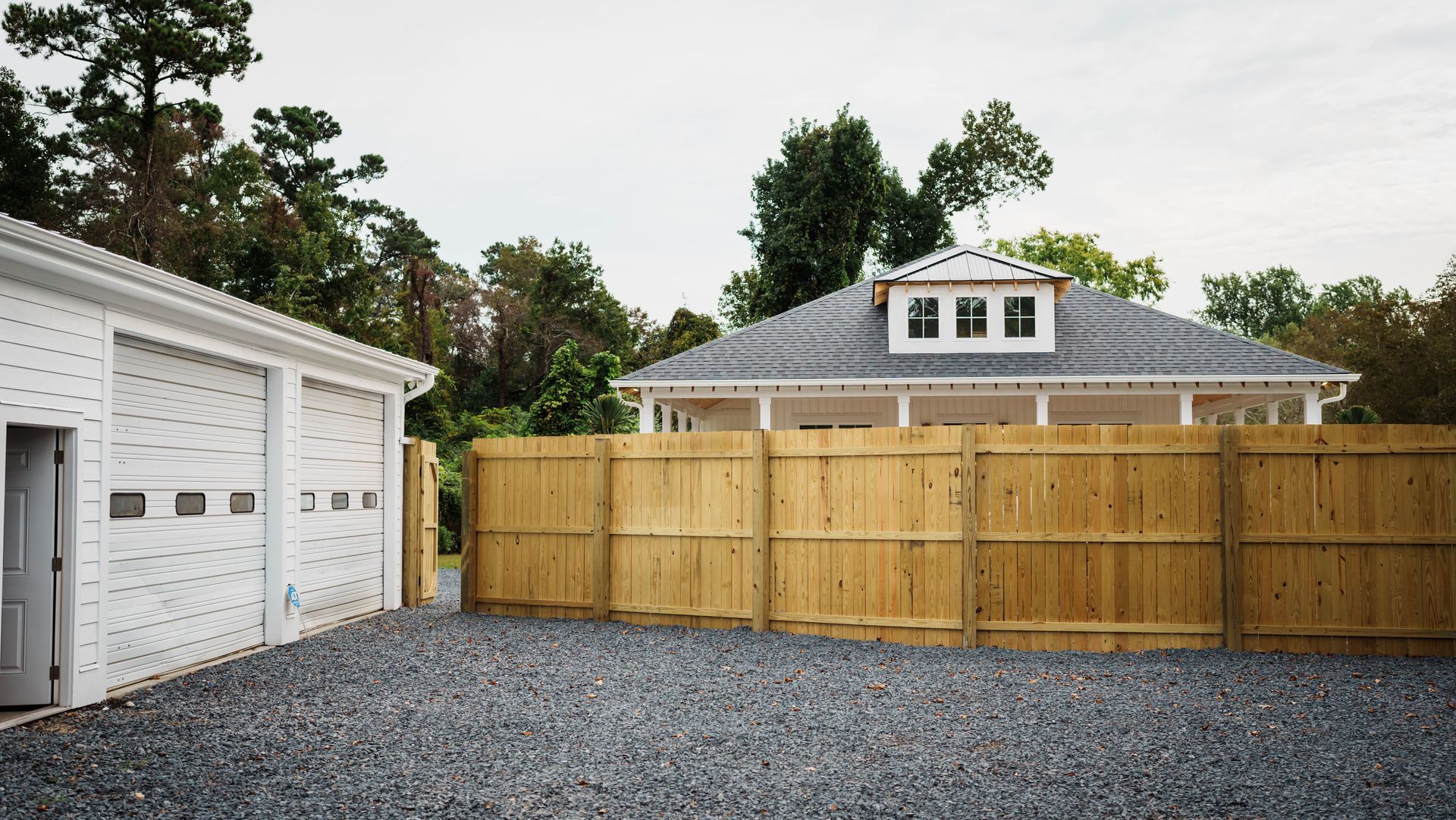 A white house with a wooden fence in front of it