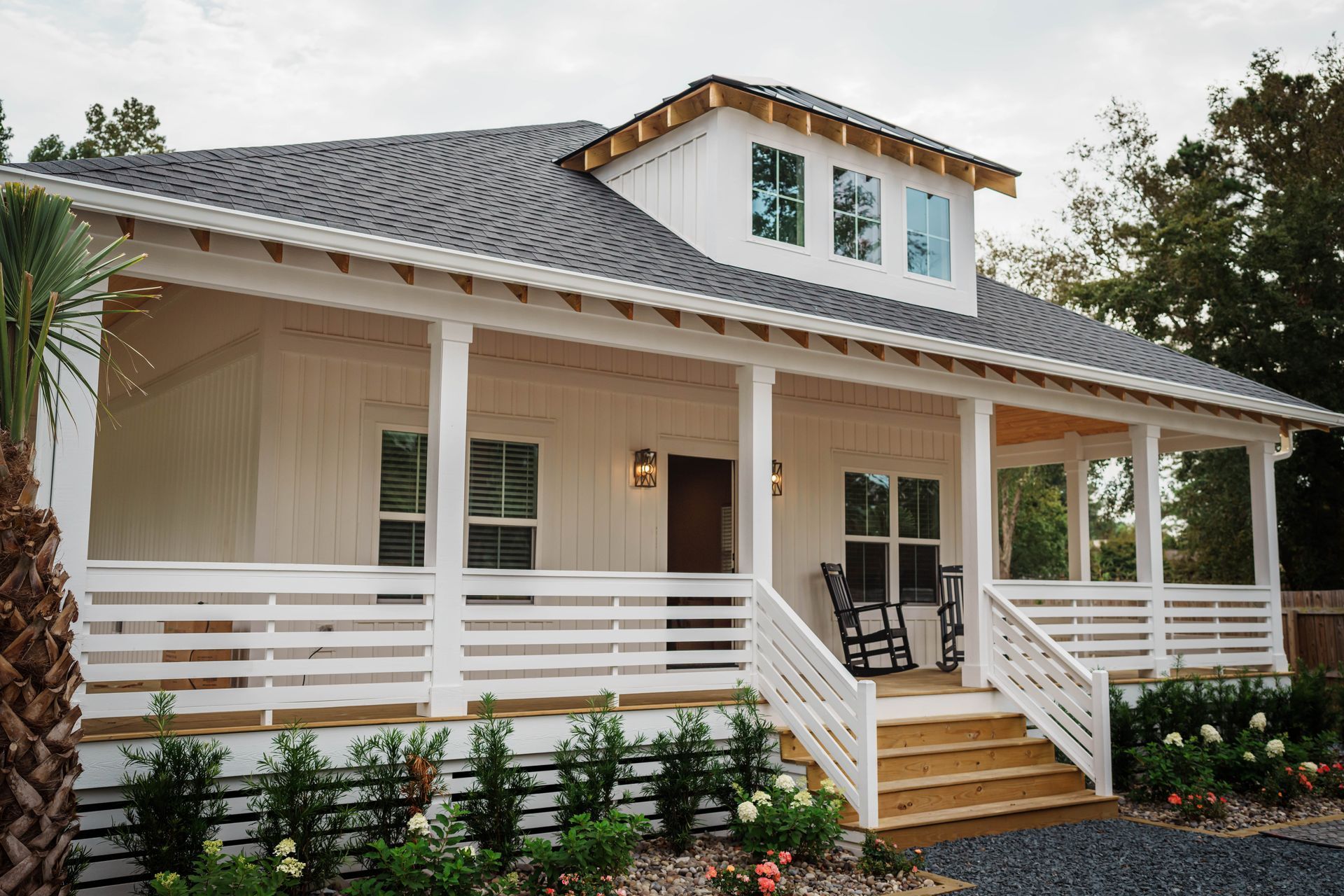 A white house with a large porch and stairs