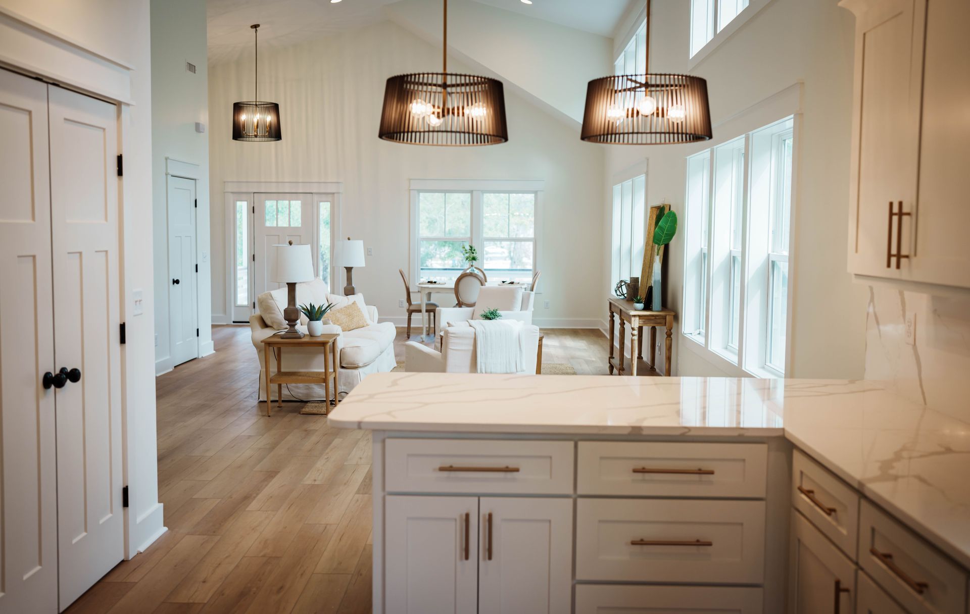 A kitchen with white cabinets and a large island in the middle