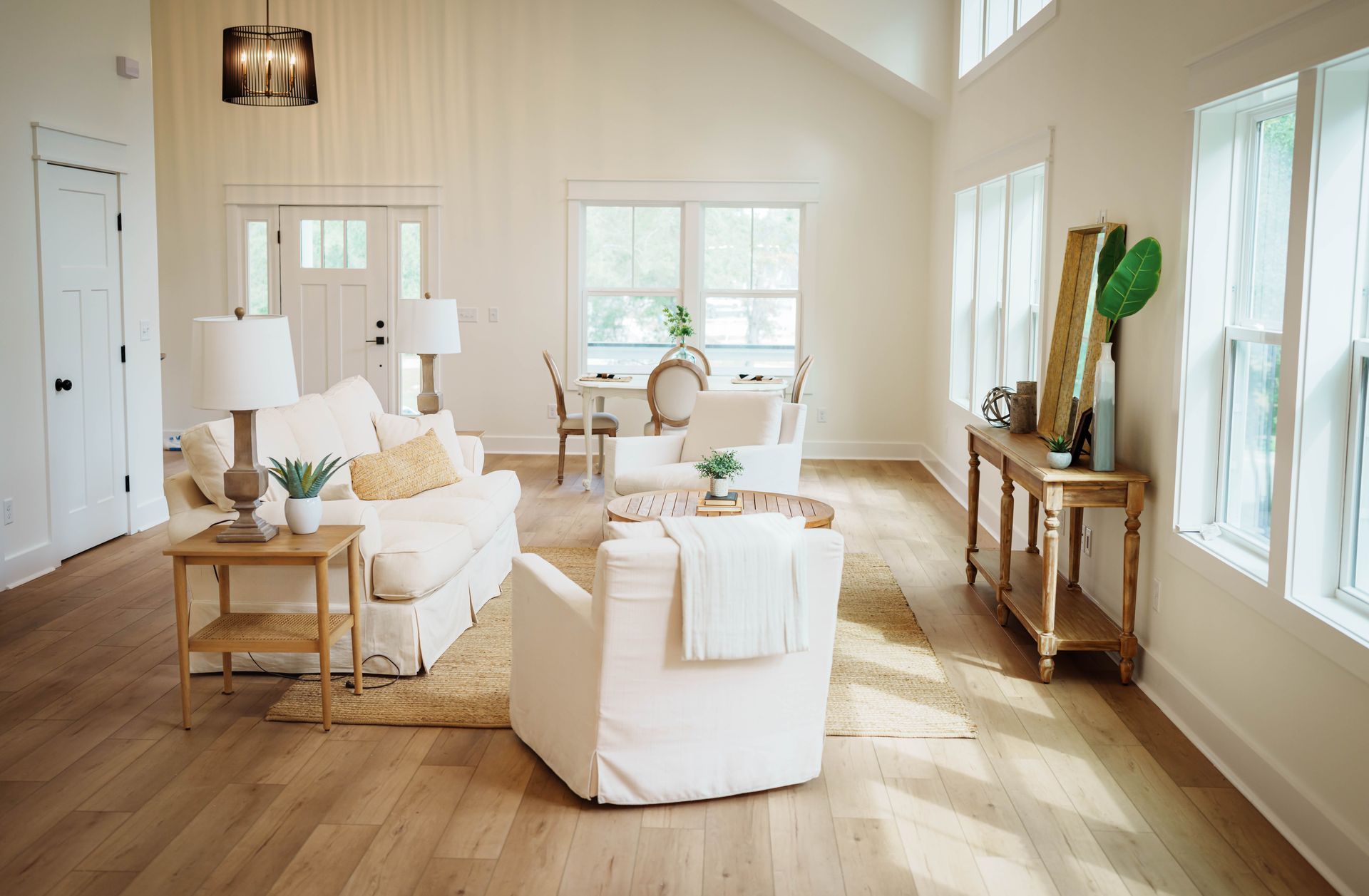 A living room with white furniture and a vaulted ceiling