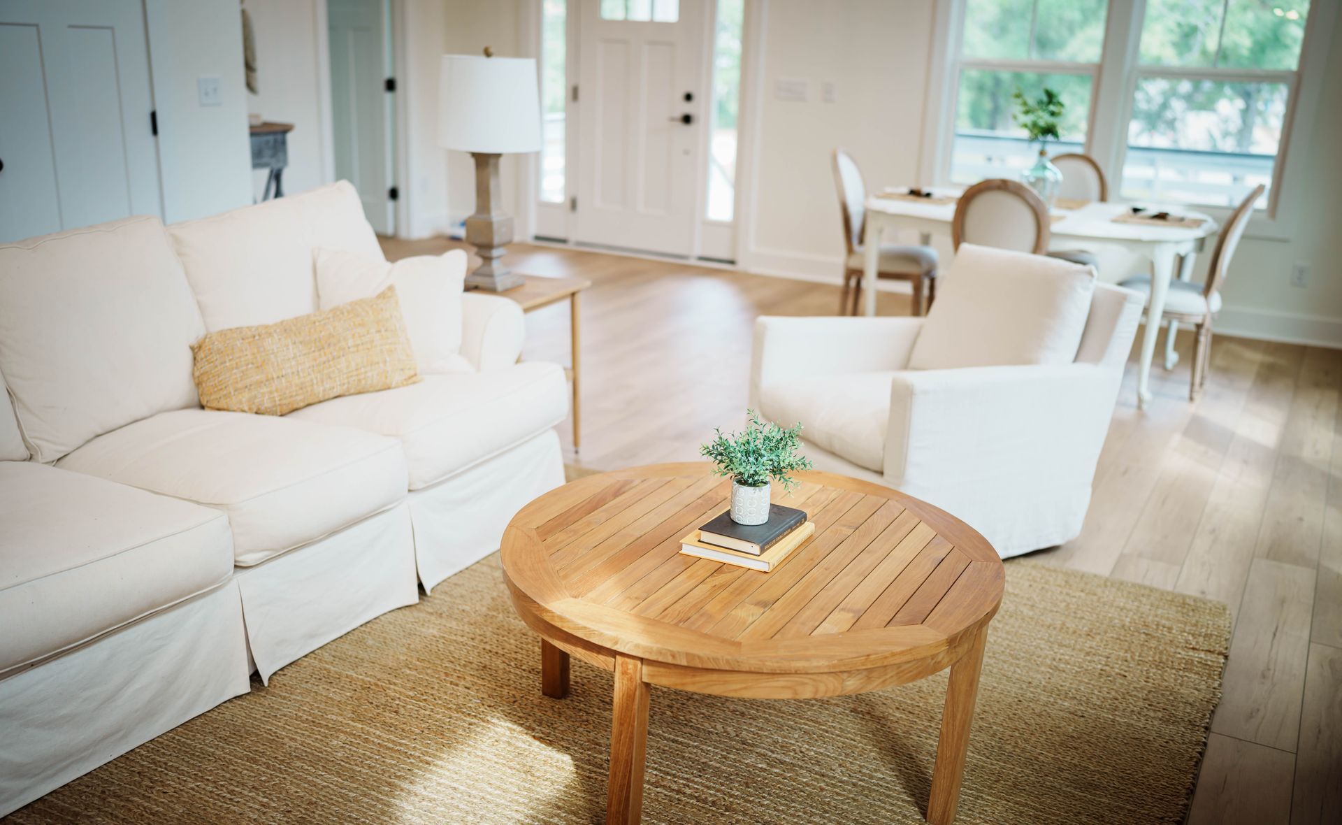 A living room with white furniture and a wooden coffee table
