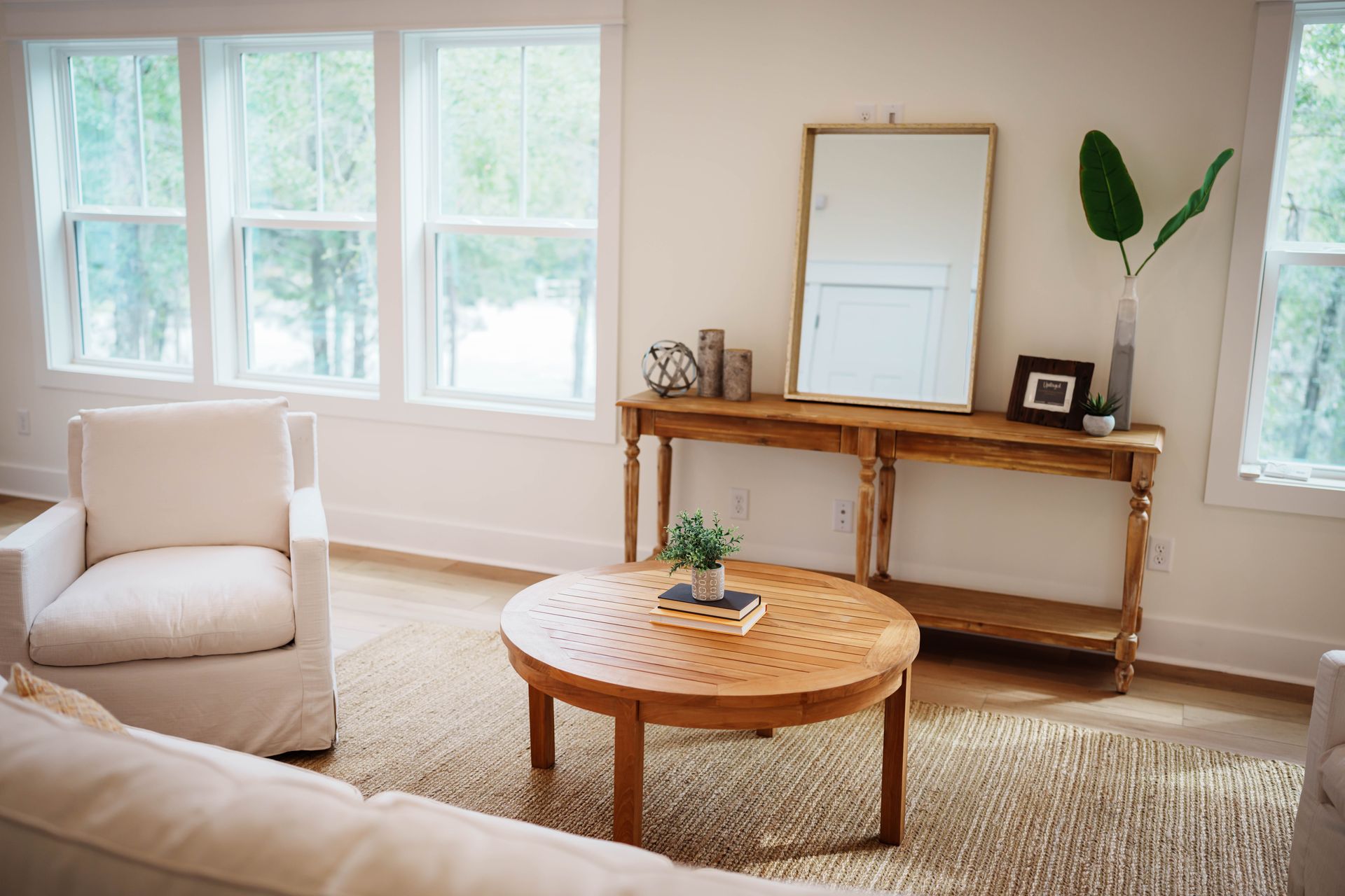 A living room with a round coffee table and a mirror