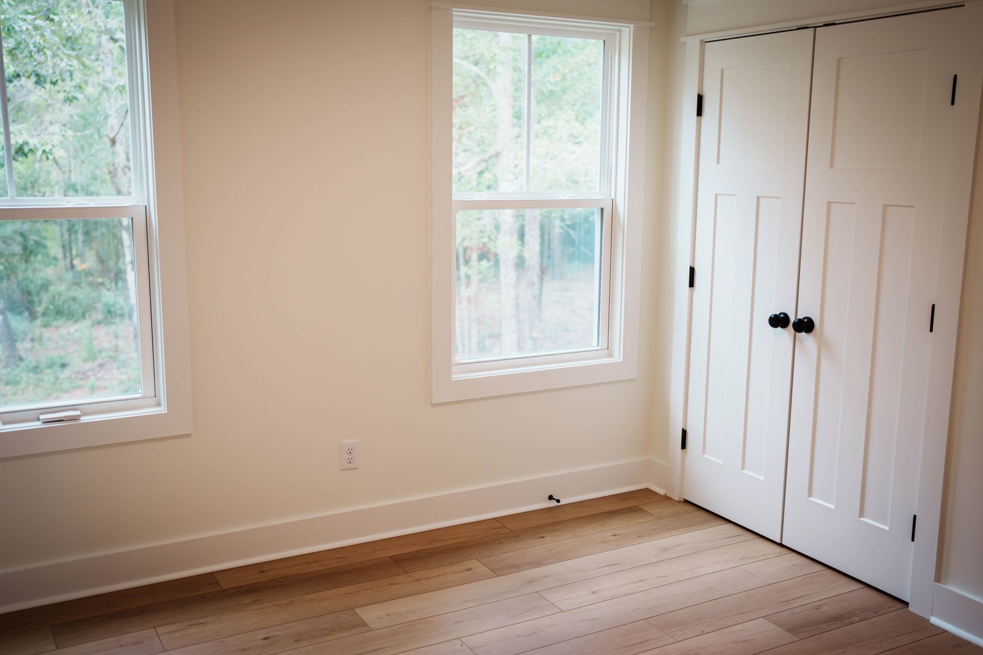 An empty room with two windows and two doors