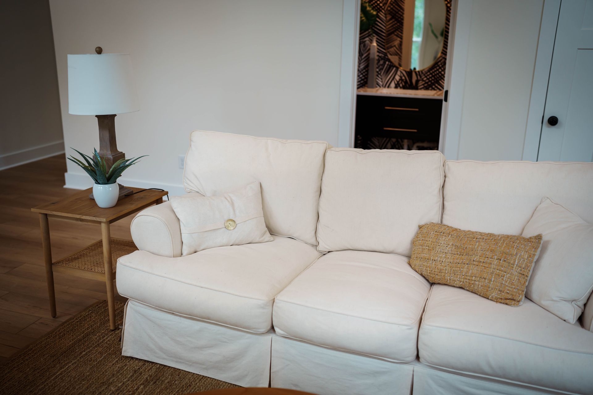 A living room with a white couch and a lamp