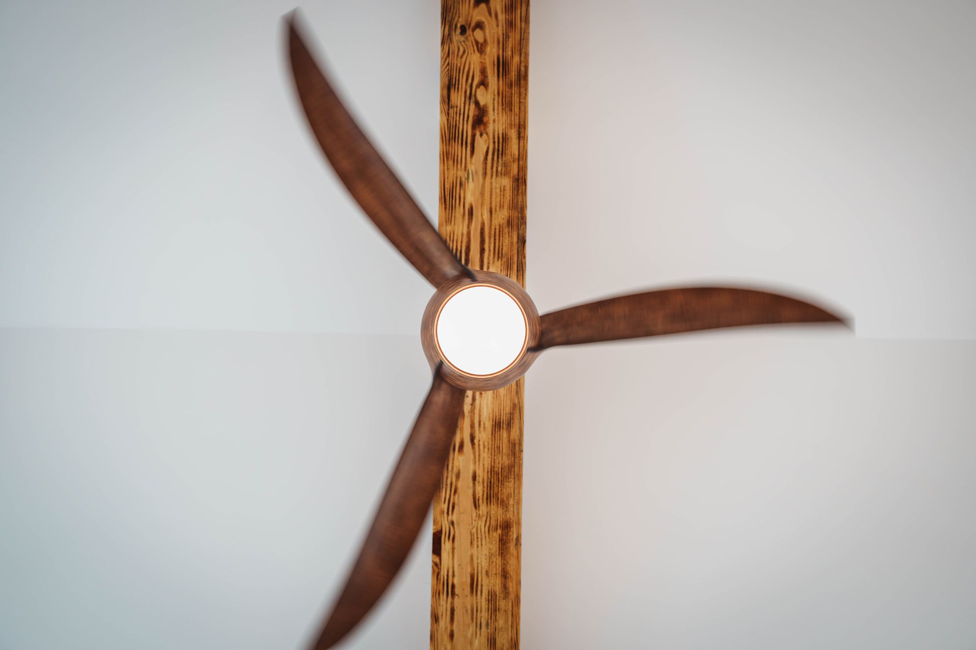 A ceiling fan is hanging from a wooden pole