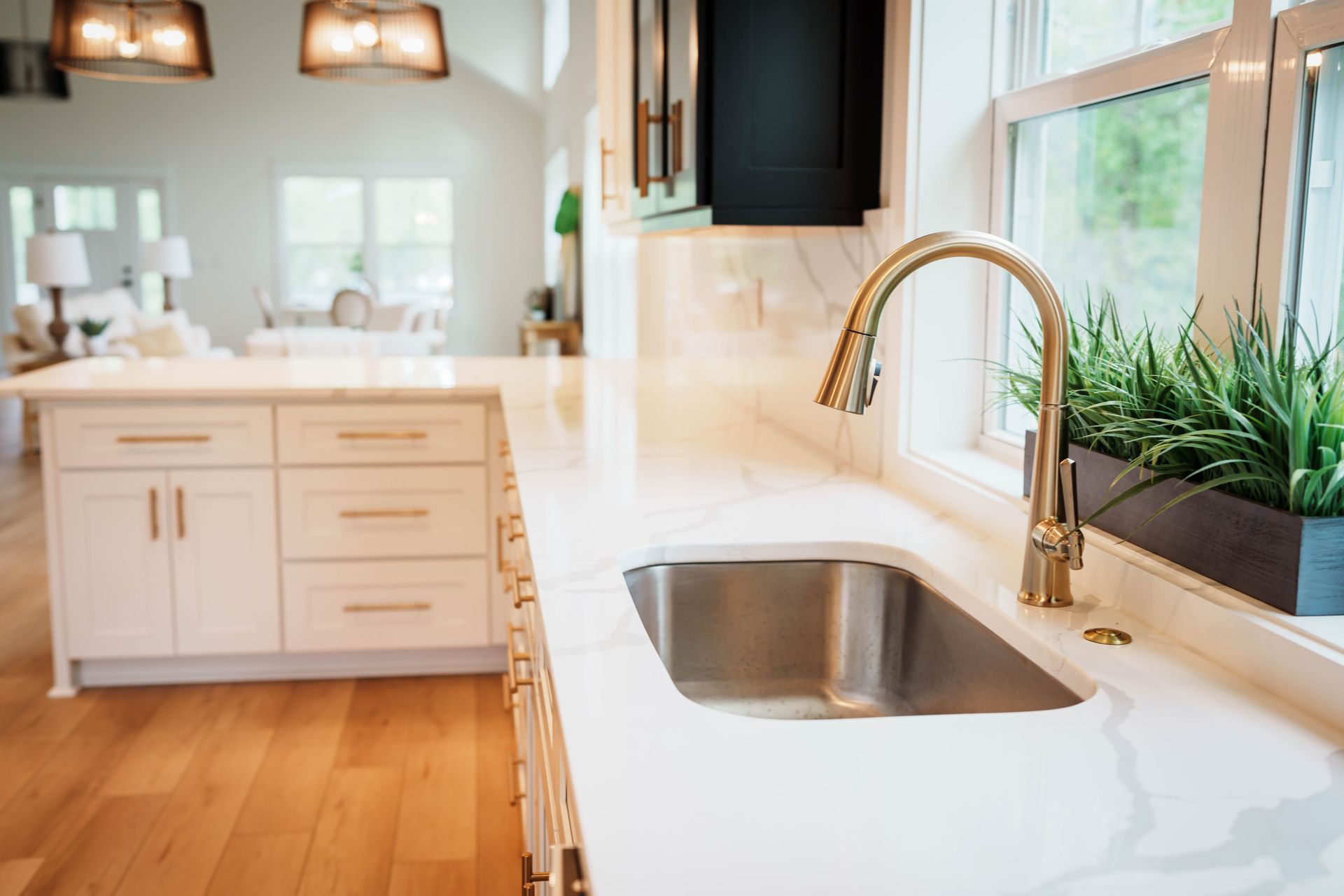 A kitchen with white cabinets and a stainless steel sink