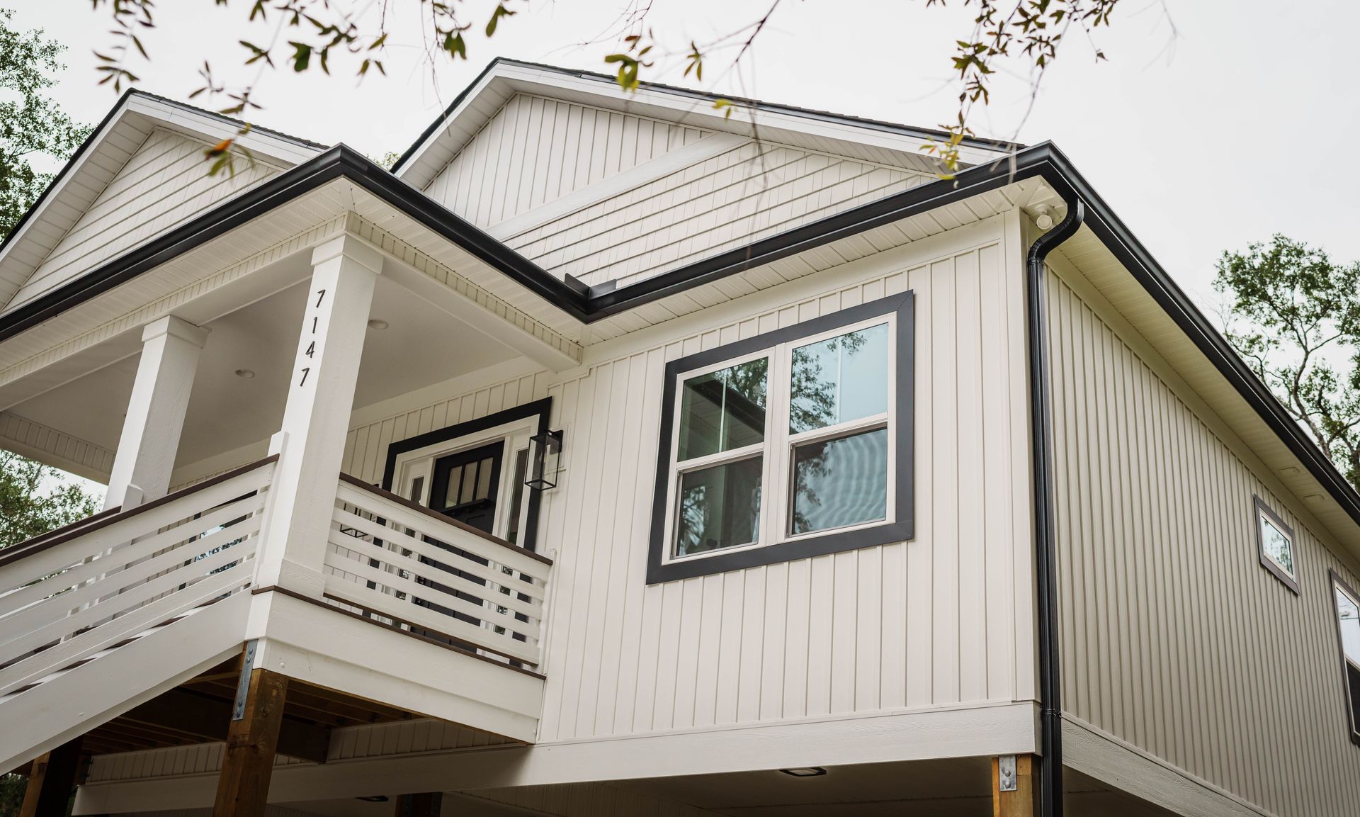 A white house with black trim and a balcony