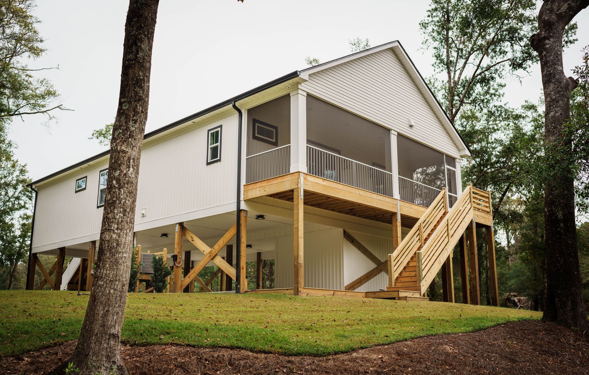 A white house with a screened in porch and stairs