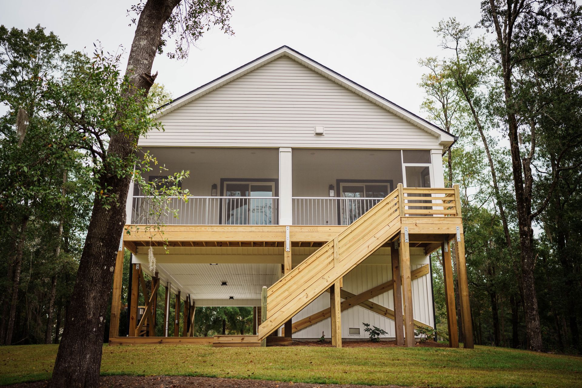 A white house with a wooden deck and stairs
