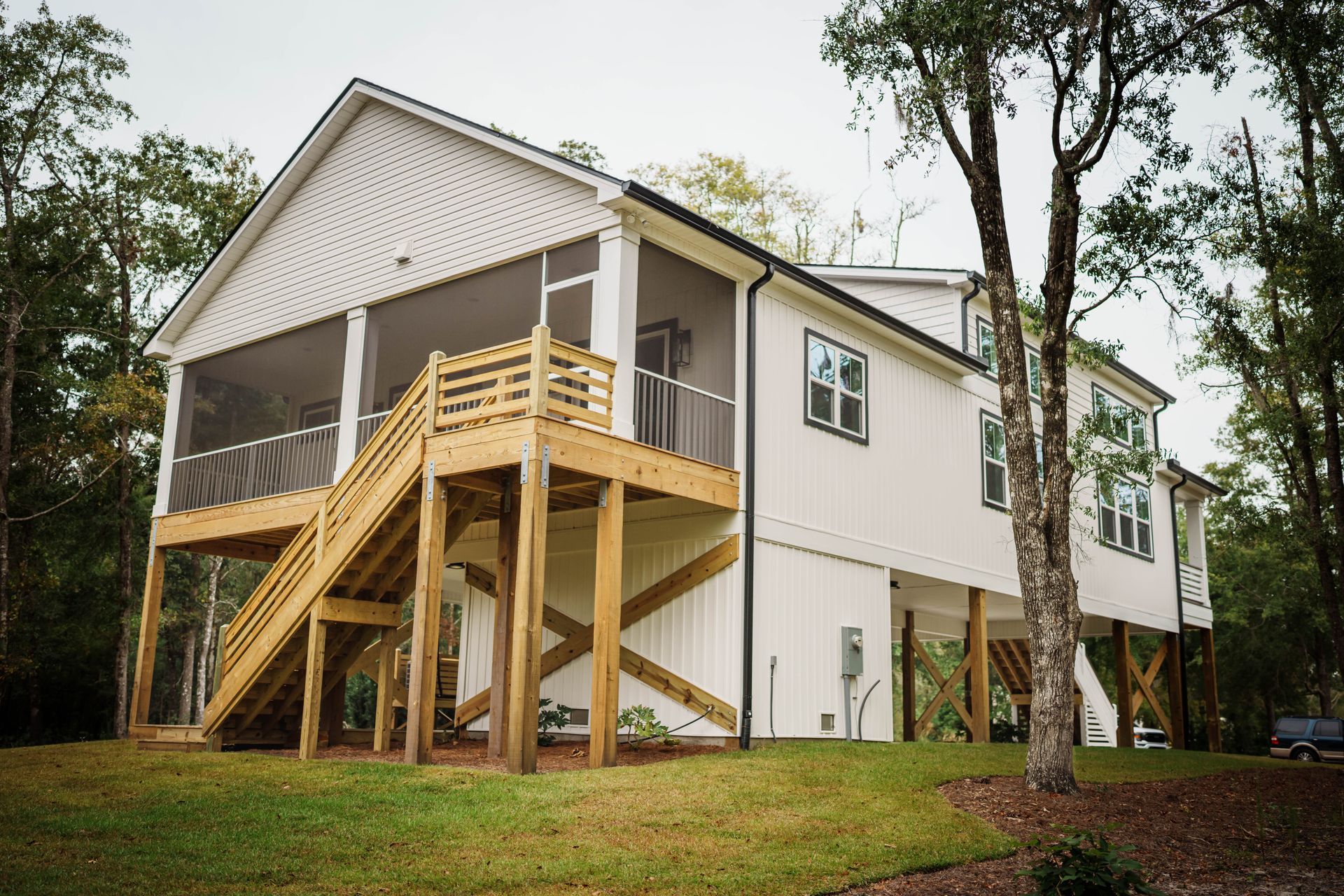 A white house with a screened in porch and stairs