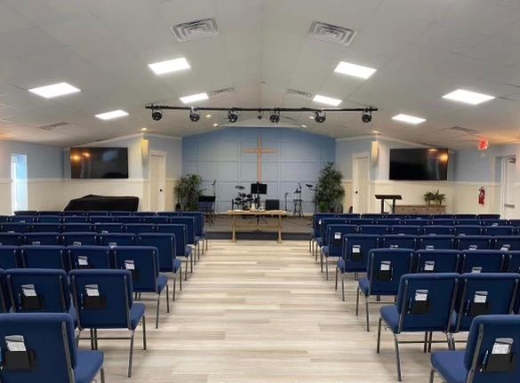 A large auditorium filled with blue chairs and a stage.