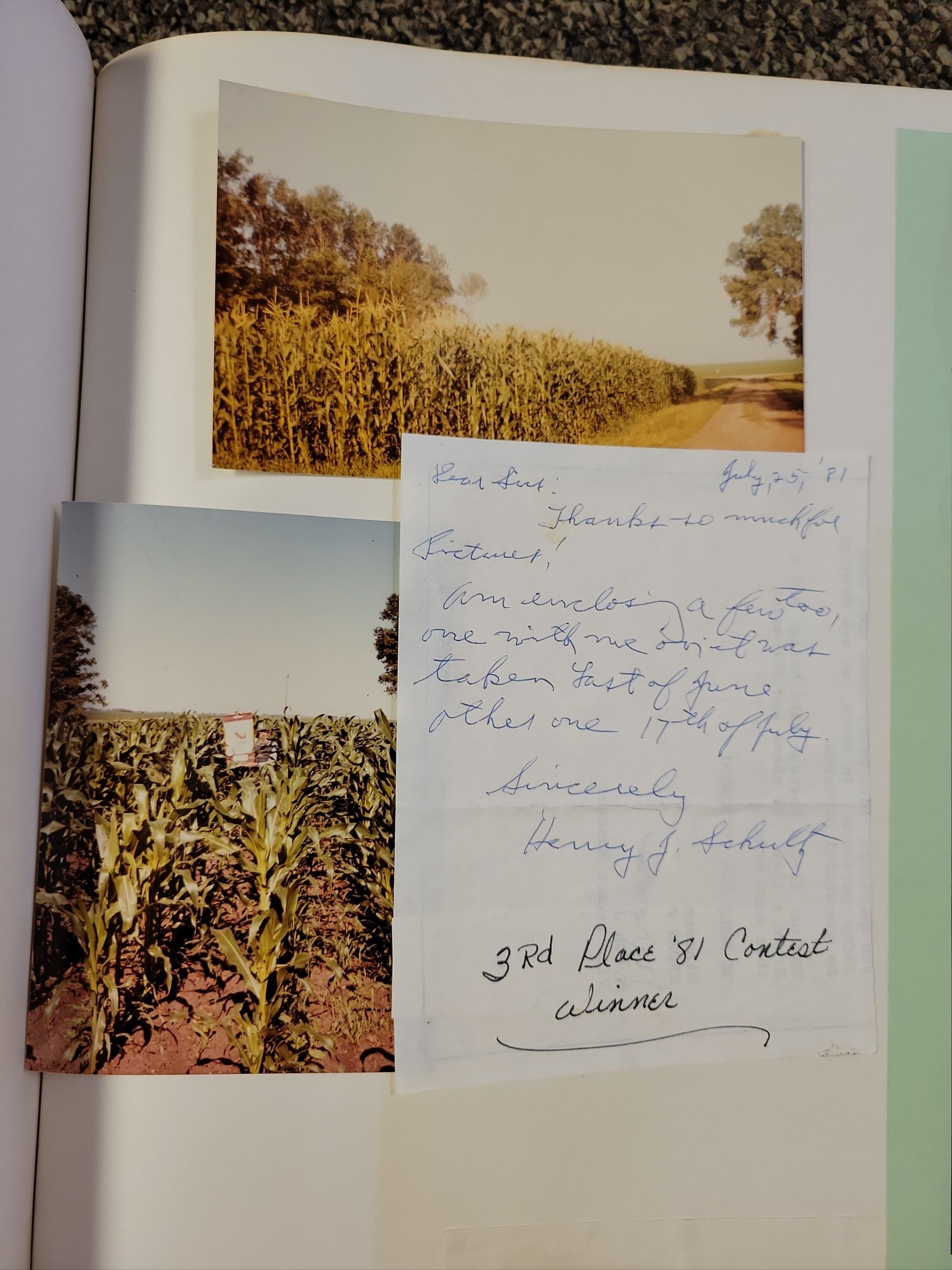 A book is open to a page with pictures of corn fields
