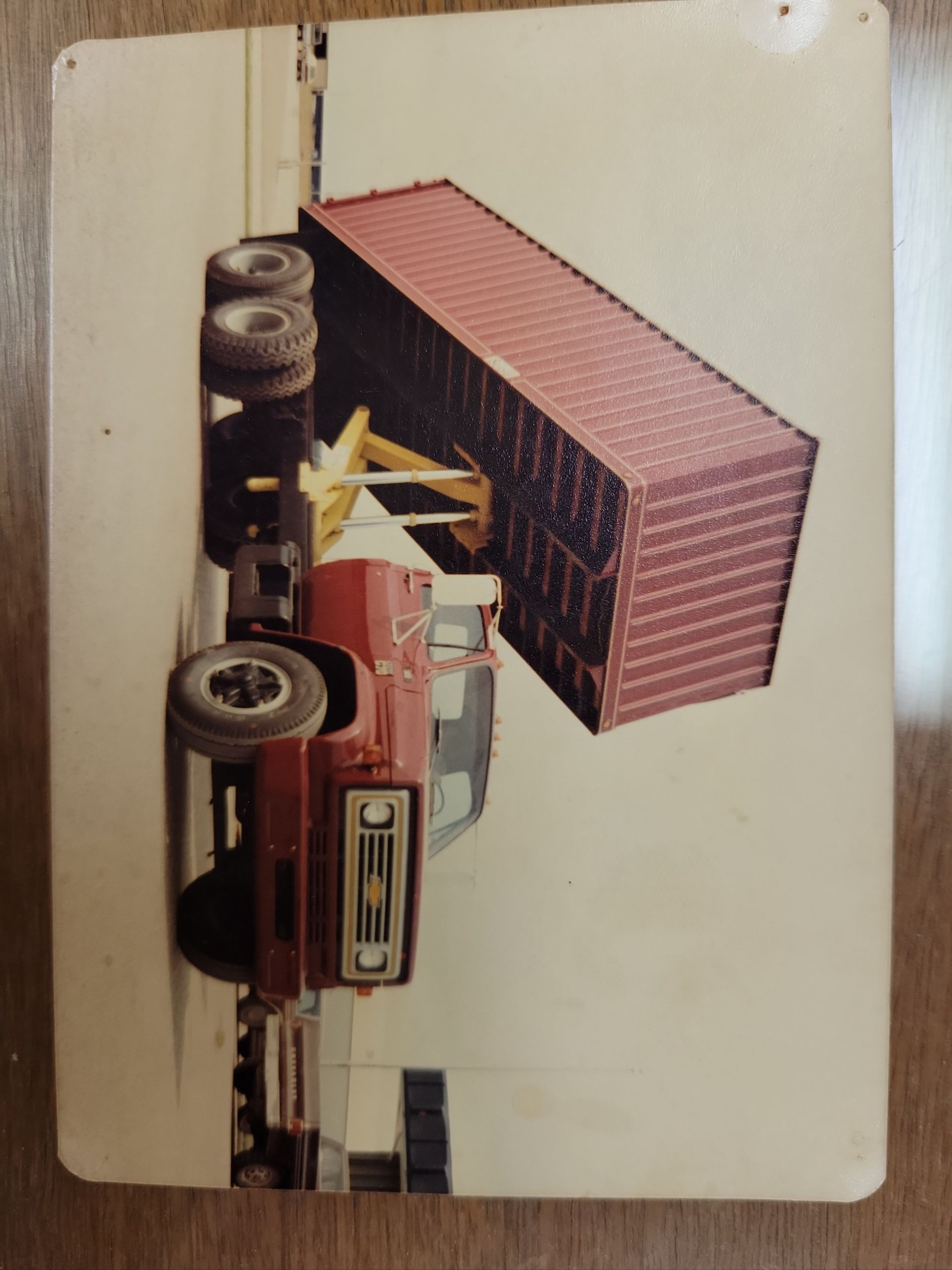A picture of a red truck with a container on the back