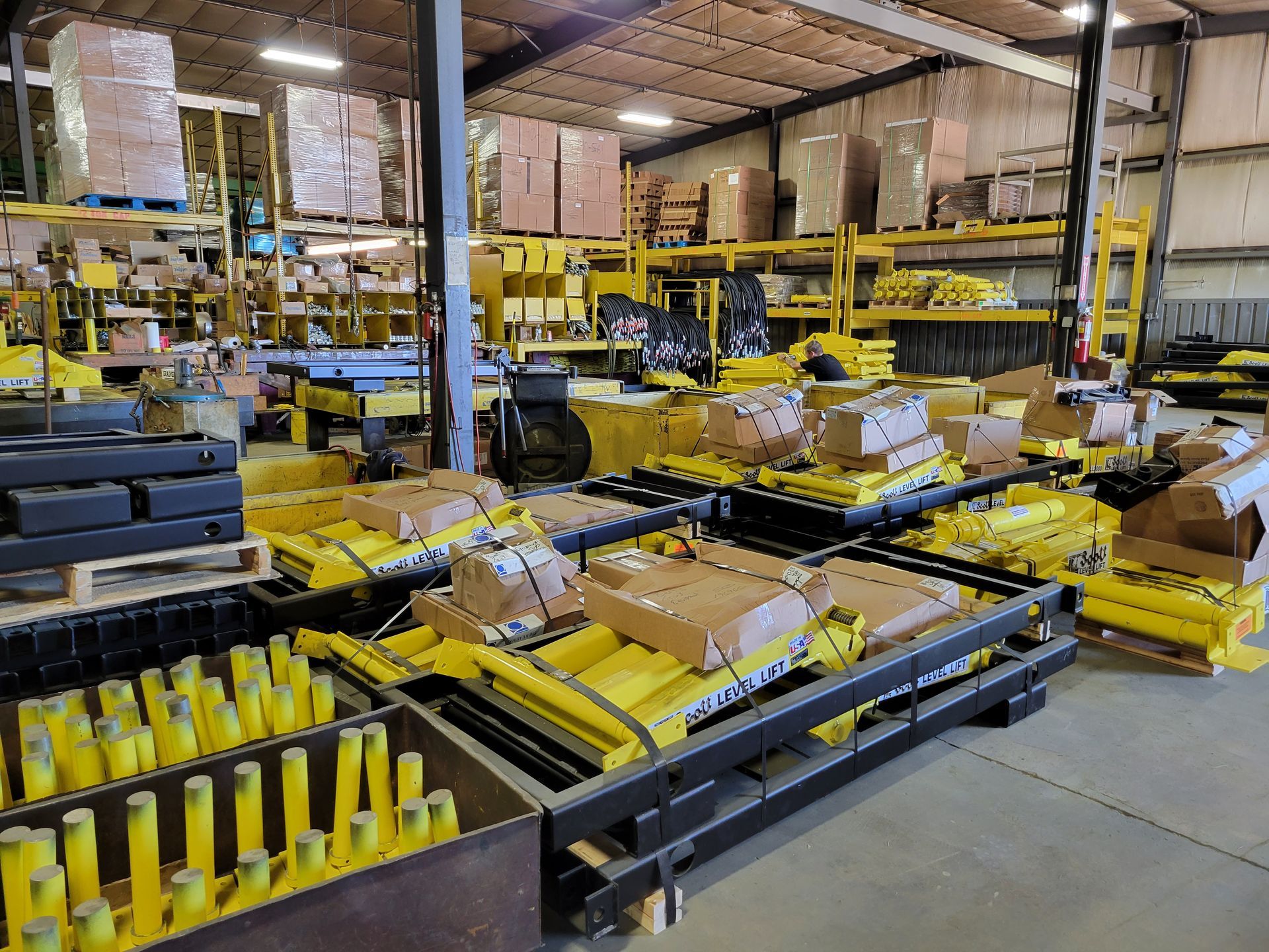 A large warehouse filled with lots of yellow equipment and boxes.