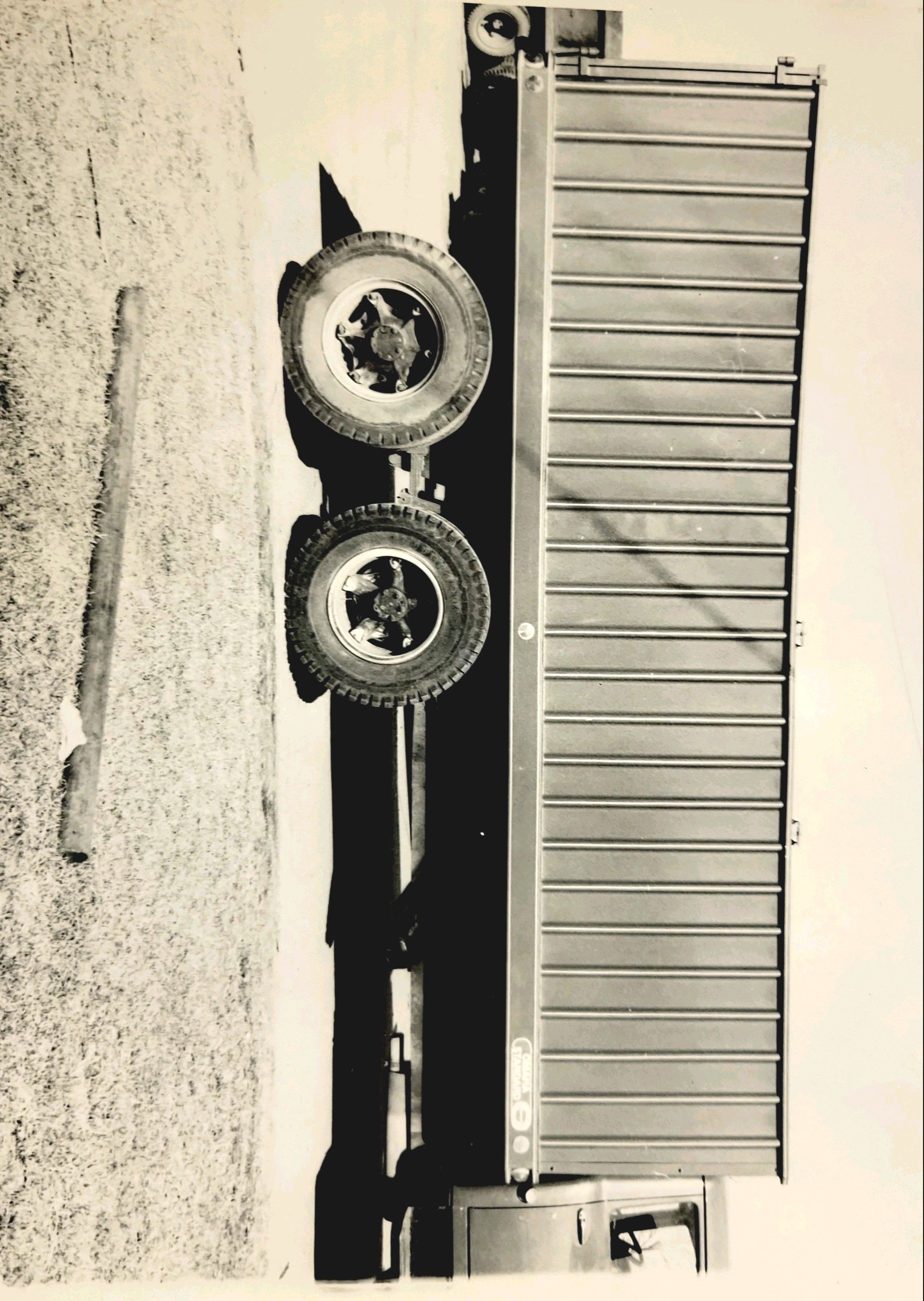 A black and white photo of a truck with a trailer